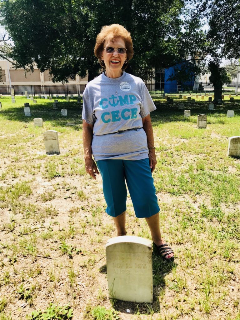 woman standing in front of gravestone-cousin camp on the coast