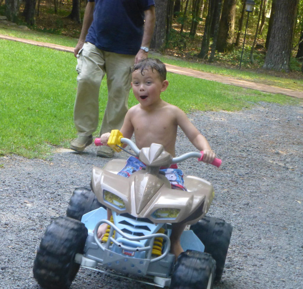 boy riding outdoor toy - camp CeCe